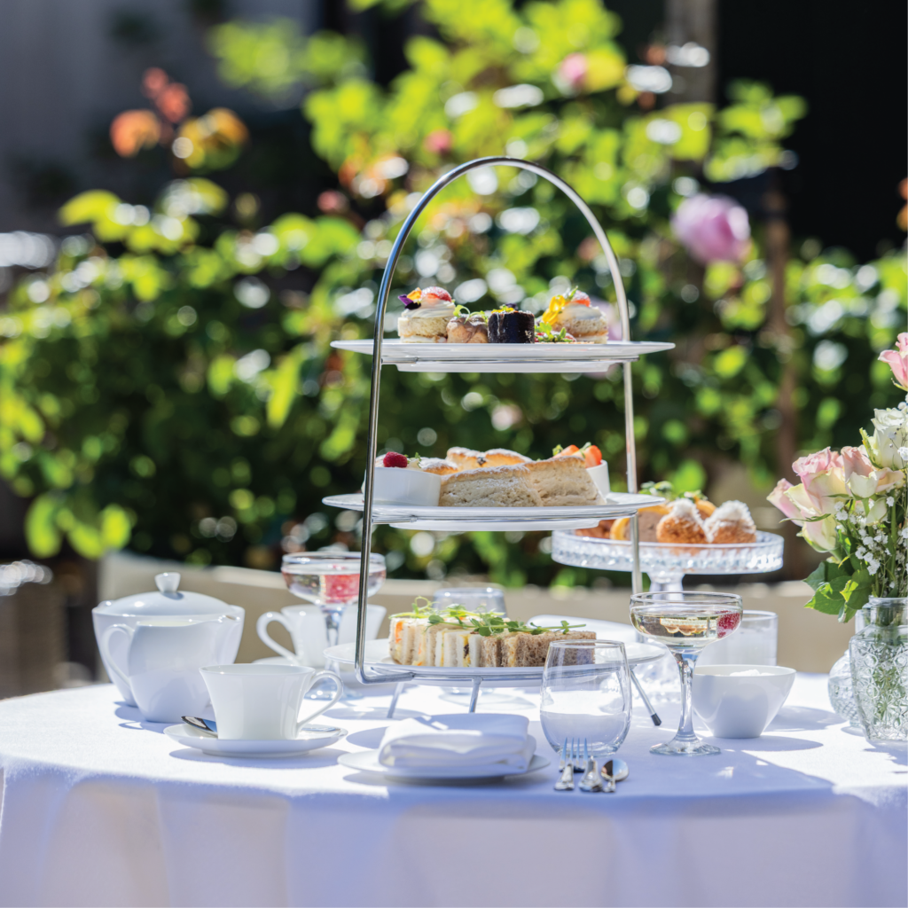 Afternoon tea stand with cakes, scones and sparkling wine at Dalton Old Pump House