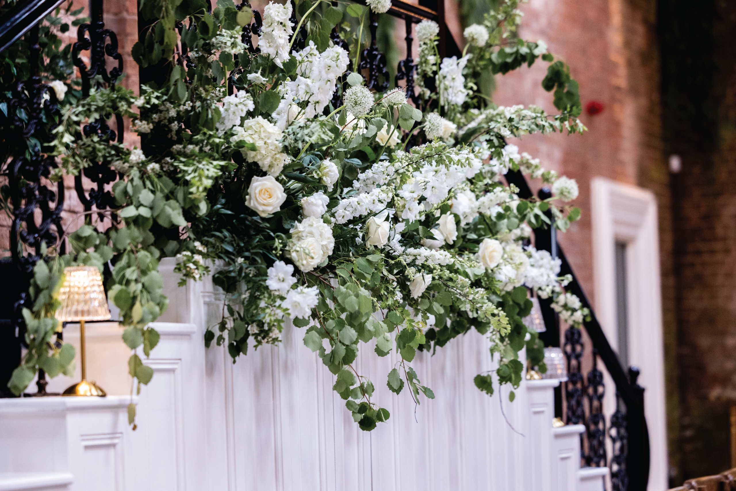 White rose and foliage floral display on a wrought-iron staircase at Dalton Old Pump House
