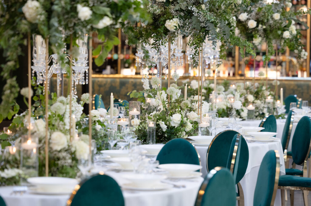 Lavish wedding reception with tall floral displays, crystal candelabra and green velvet chairs at Dalton Old Pump House
